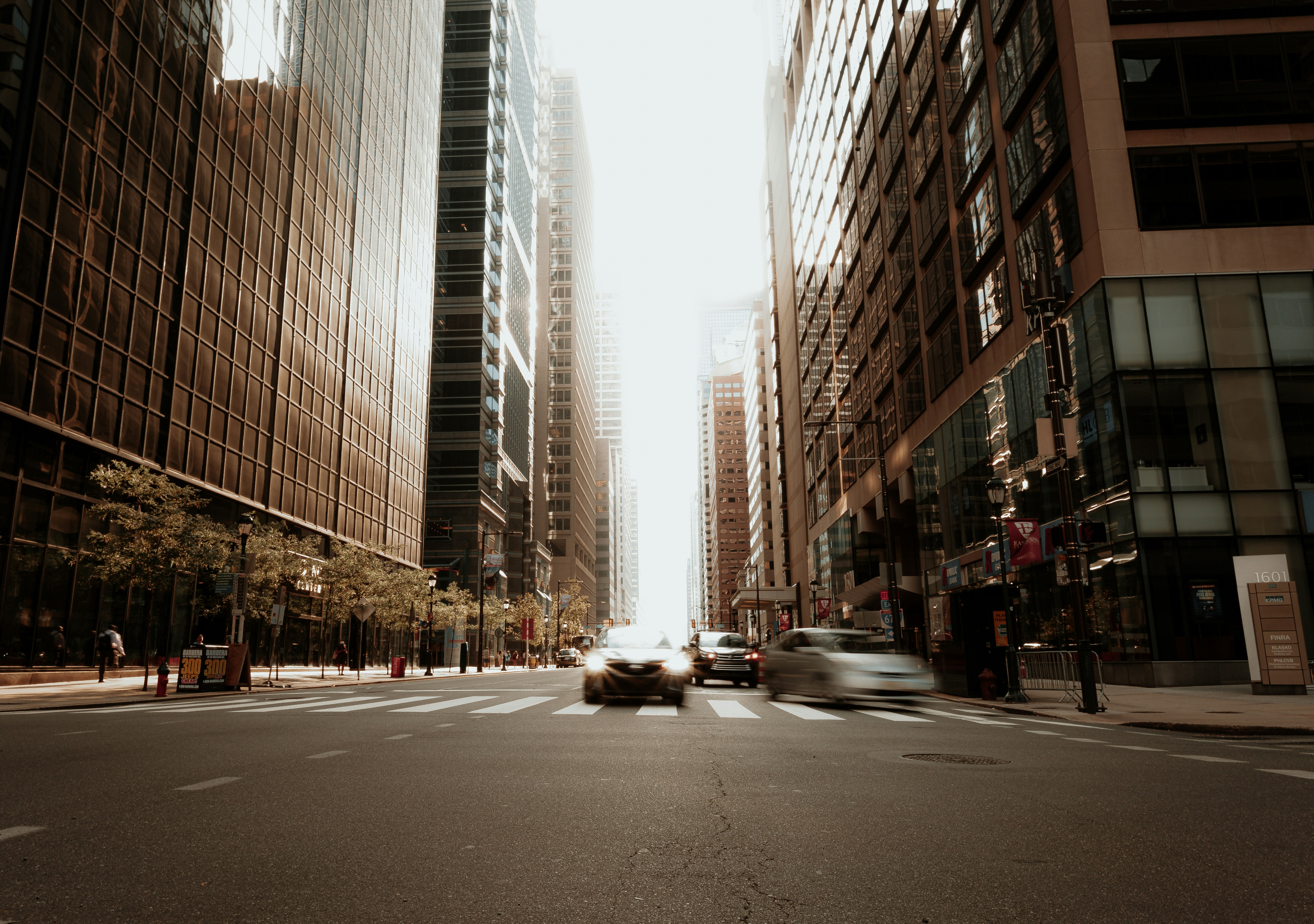 cars on road between high rise buildings during daytime